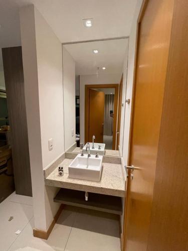 a bathroom with a sink and a large mirror at Flat Rio Centro, 1km do Rio centro 3km da Jeunesse Arena Parque Olímpico em frente ao Projac e a poucos minutos da Praia da Barra in Rio de Janeiro