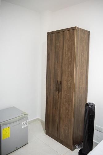 a wooden cabinet sitting next to a refrigerator at Alojamiento Acogedor con excelente ubicacion D in Medellín