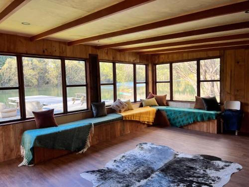 a room with couches and windows in a house at Blue Mountain Lake Lodge in Fairlie