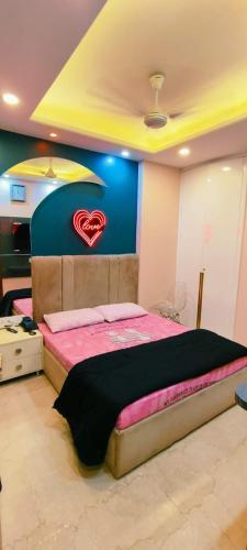 a bedroom with a bed with a heart on the wall at Vinanda Home Stay in New Delhi