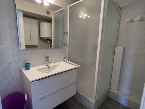 une salle de bain blanche avec un lavabo et un miroir dans l'établissement Appartement Climatisé T2+Cabine, 4 Couchages, Parking, à 450m de la Plage – Port Leucate - FR-1-81-595, à Port-Leucate