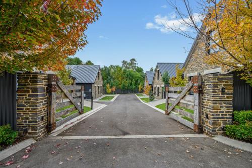 a driveway leading into a house with a wooden gate at Vale 194 - Luxury Accommodation in McLaren Vale - 5 holiday homes with king size beds in McLaren Vale
