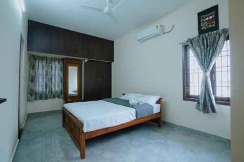 1 dormitorio con 1 cama con sábanas blancas y ventana en Live Inn JP Nagar, en Tiruchchirāppalli