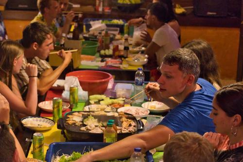 a group of people sitting around a table eating food at The Funky Monkey Hostel - 18 to 40 years old only in Haad Rin