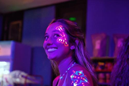 una mujer con luces rosas en su cara en The Funky Monkey Hostel en Haad Rin