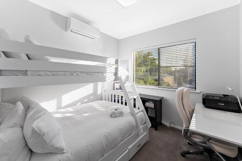 Un dormitorio con una litera y un escritorio con una computadora. en Modern Scarborough Townhouse, en Perth