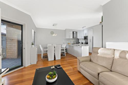 a living room with a couch and a table at Modern Scarborough Townhouse in Perth