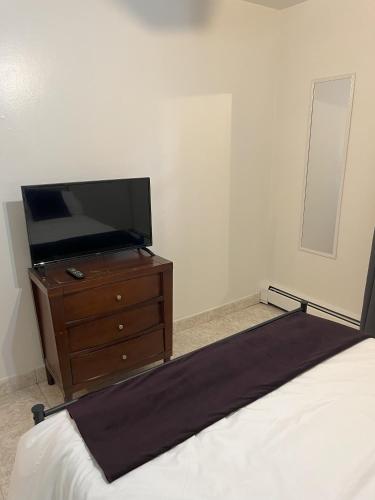 a bedroom with a bed and a tv on a dresser at Two Bedroom Private Apt near NYC in West New York