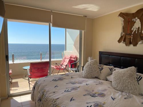 a bedroom with a bed and a view of the ocean at Vacations in La Serena in La Serena