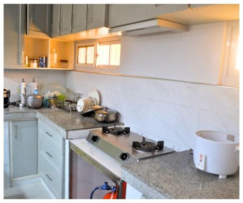 una cucina con lavandino e piano cottura forno superiore di Velasquez Farmhouse/Affordable Holiday Rental Near Hundred Islands 