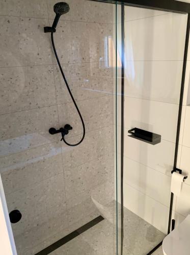 a shower with a glass door in a bathroom at Baltic Homes Lubiatowo in Lubiatowo