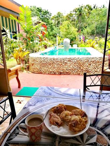 a plate of food on a table next to a pool at EDMUND's GARDEN INN in Siquijor