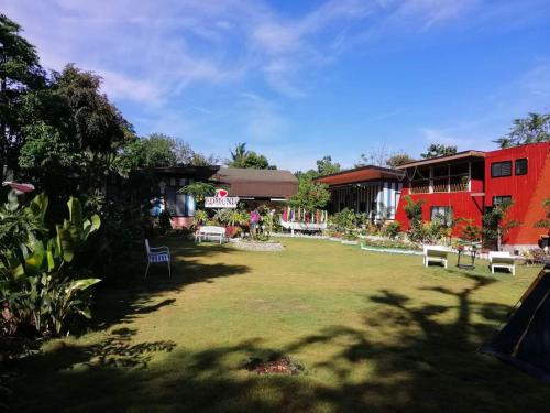 a large yard with chairs and a building at EDMUND's GARDEN INN in Siquijor