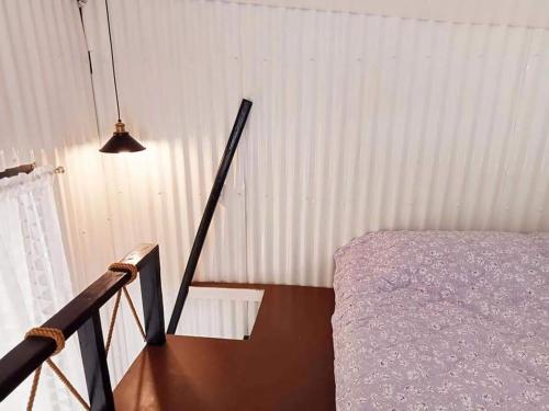 a bedroom with a bed and a pendant light at EDMUND's GARDEN INN in Siquijor