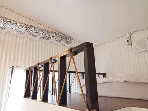 a room with a bed and a staircase with curtains at EDMUND's GARDEN INN in Siquijor
