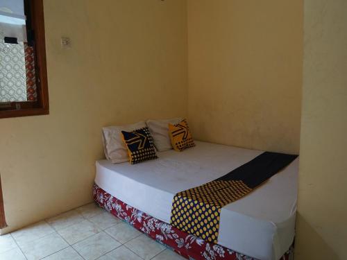 a small room with a bed with pillows on it at SPOT ON 92666 Rumah Kos Arafah Syariah in Probolinggo