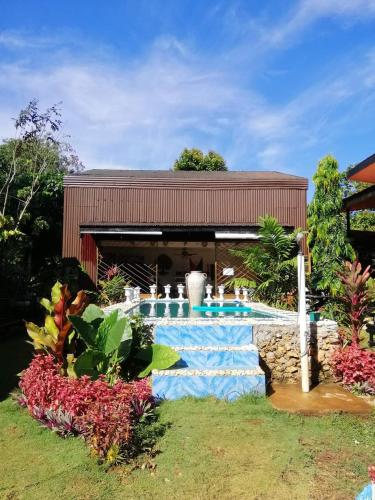 a house with a swimming pool in a yard at EDMUND's GARDEN INN in Siquijor