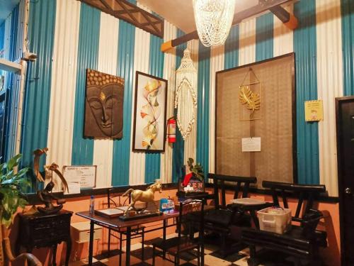a room with blue and white striped walls and tables at EDMUND's GARDEN INN in Siquijor
