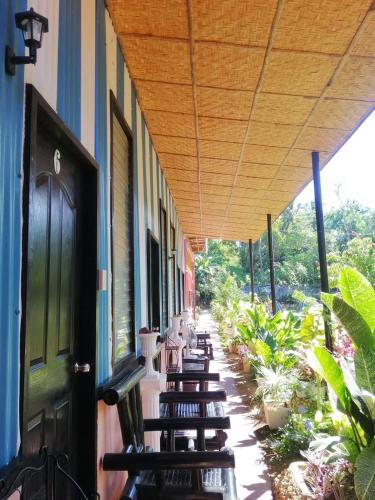 a row of chairs sitting on a porch with awning at EDMUND's GARDEN INN in Siquijor