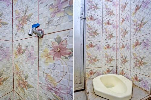 La salle de bains est pourvue de toilettes et de fleurs sur le mur. dans l'établissement SPOT ON 92673 Gang Songo Syariah Homestay, à Banyuwangi