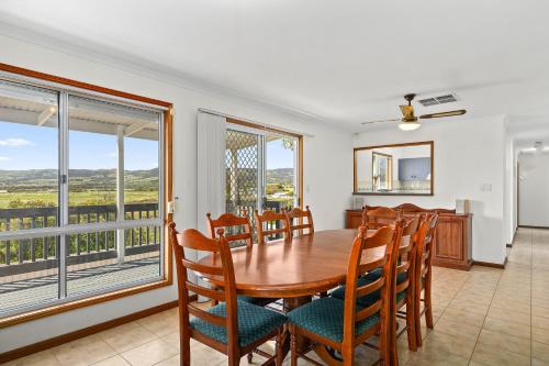 a dining room with a table and chairs and a balcony at The Love Shack - Silver Sands - C21 SouthCoast Holidays in Aldinga Beach