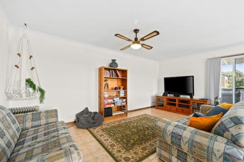 a living room with two couches and a flat screen tv at The Love Shack - Silver Sands - C21 SouthCoast Holidays in Aldinga Beach