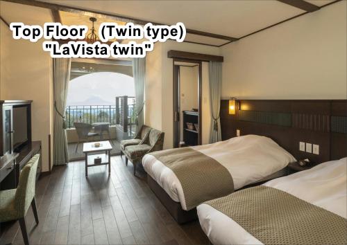 a hotel room with two beds and a television at La Vista Kirishima Hills in Kirishima