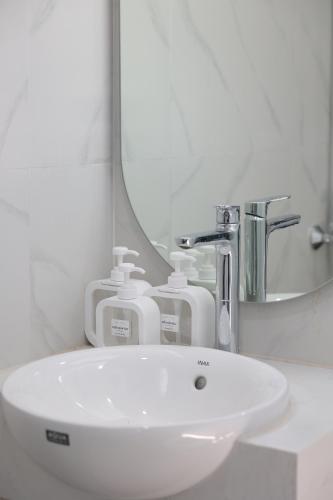 河內的住宿－The Cosy Inn Hanoi，浴室设有白色水槽和镜子