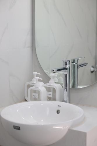a bathroom with a white sink and a mirror at The Cosy Inn Hanoi in Hanoi