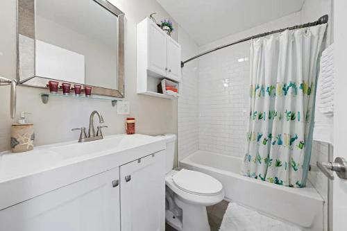 a white bathroom with a toilet and a sink at Spacious Centrally Located NEW 2 Bedroom Property! in Inglewood