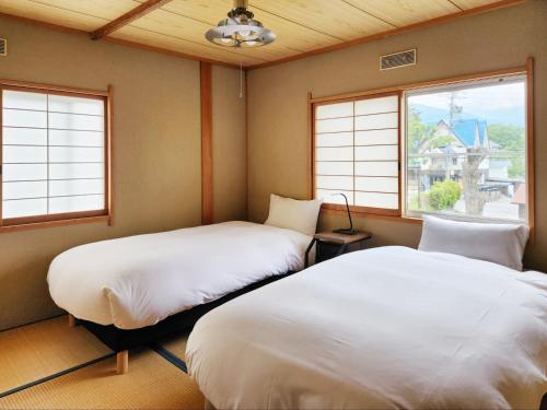 白馬的住宿－Hakuba Echoland Cottage，带2扇窗户的客房内的2张床