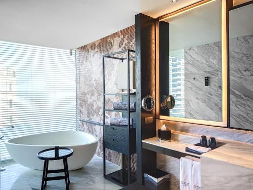 a bathroom with a tub and a sink and a mirror at The Shanhaitian Resort Sanya, Autograph Collection in Sanya