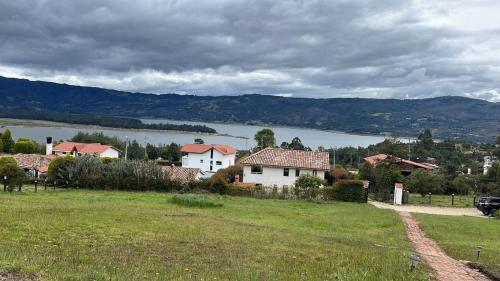 un grupo de casas en una colina junto a un lago en Glamping BRILLO DE LUNA, en Guatavita