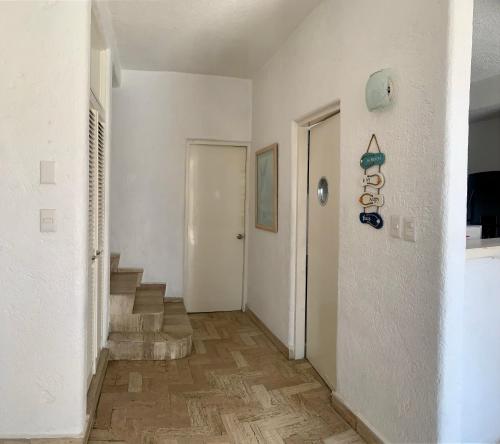 a hallway with a white door and stairs in a building at Tiki’s Penth in Acapulco