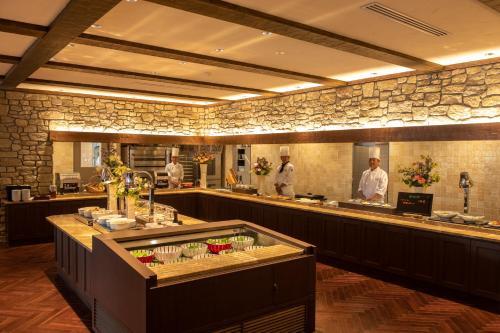 a restaurant with three chefs in the kitchen at La Vista Kirishima Hills in Kirishima