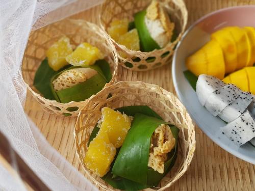four bamboo baskets filled with different types of food at Kedthawa Homestay เฮือนเก็ดถะหวา in Ban Cho Lae