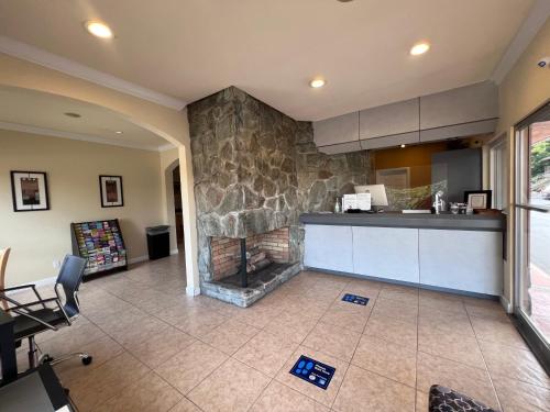 a kitchen with a stone fireplace in a room at Inn at San Luis Obispo in San Luis Obispo