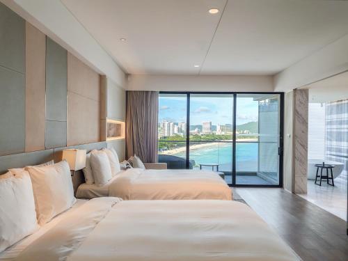 two beds in a hotel room with a view at The Shanhaitian Resort Sanya, Autograph Collection in Sanya