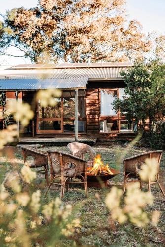 a fire pit in front of a log cabin at Ilkley House - A Refreshing Family Rural Getaway in Mudgee