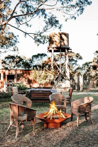 a fire pit in a yard with chairs and a table at Ilkley House - A Refreshing Family Rural Getaway in Mudgee