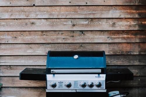 a grill sitting in front of a wooden wall at Ilkley House - A Refreshing Family Rural Getaway in Mudgee