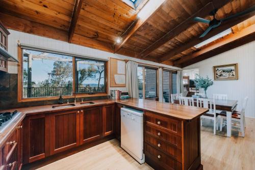 a kitchen with wooden cabinets and a table and chairs at Ilkley House - A Refreshing Family Rural Getaway in Mudgee