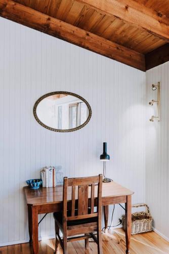 a wooden table with a chair and a mirror at Ilkley House - A Refreshing Family Rural Getaway in Mudgee