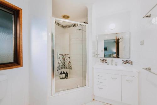 a white bathroom with a shower and a sink at Ilkley House - A Refreshing Family Rural Getaway in Mudgee