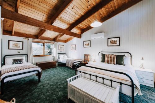 a bedroom with two beds and a wooden ceiling at Ilkley House - A Refreshing Family Rural Getaway in Eurunderee