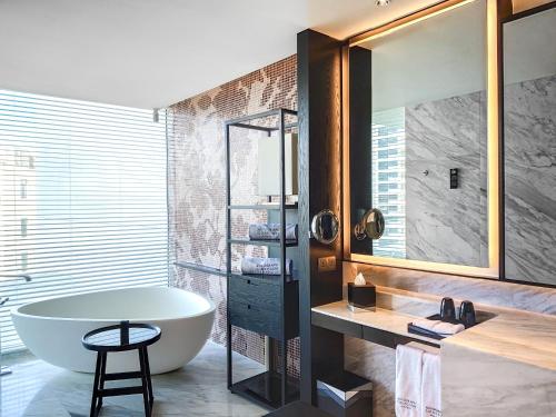 a bathroom with a tub and a sink and a mirror at The Shanhaitian Resort Sanya, Autograph Collection in Sanya