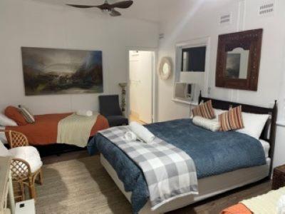 a bedroom with two beds and a ceiling fan at The Oasis Tamworth in Tamworth