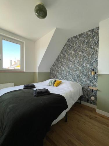 Un dormitorio con una cama grande y una ventana en TheLighthouse Logement cozy idéalement situé, en Calais