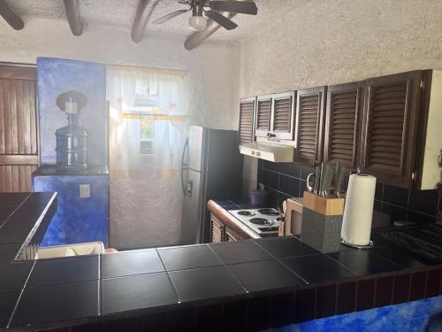 a kitchen with a black counter top and a stove at Casa villas del pacifico en puerto San José in San José de Guatemala