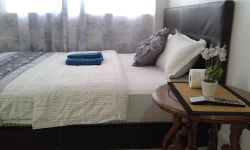 a bed with a night stand next to a table at Best Seven Inn in Kuah